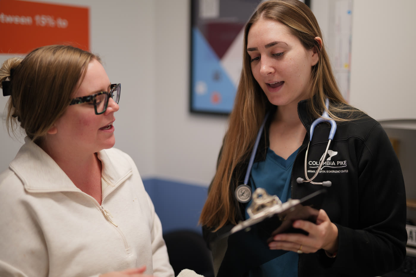 A Columbia Pike veterinarian going through an exam plan with a client