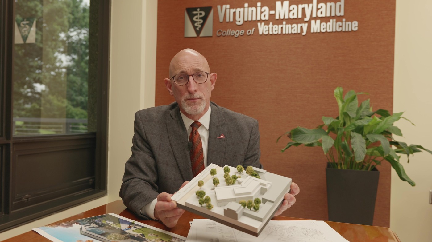 Dean Dan Givens of the Virginia-Maryland College of Veterinary Medicine holding a model of the teaching hospital project in his office